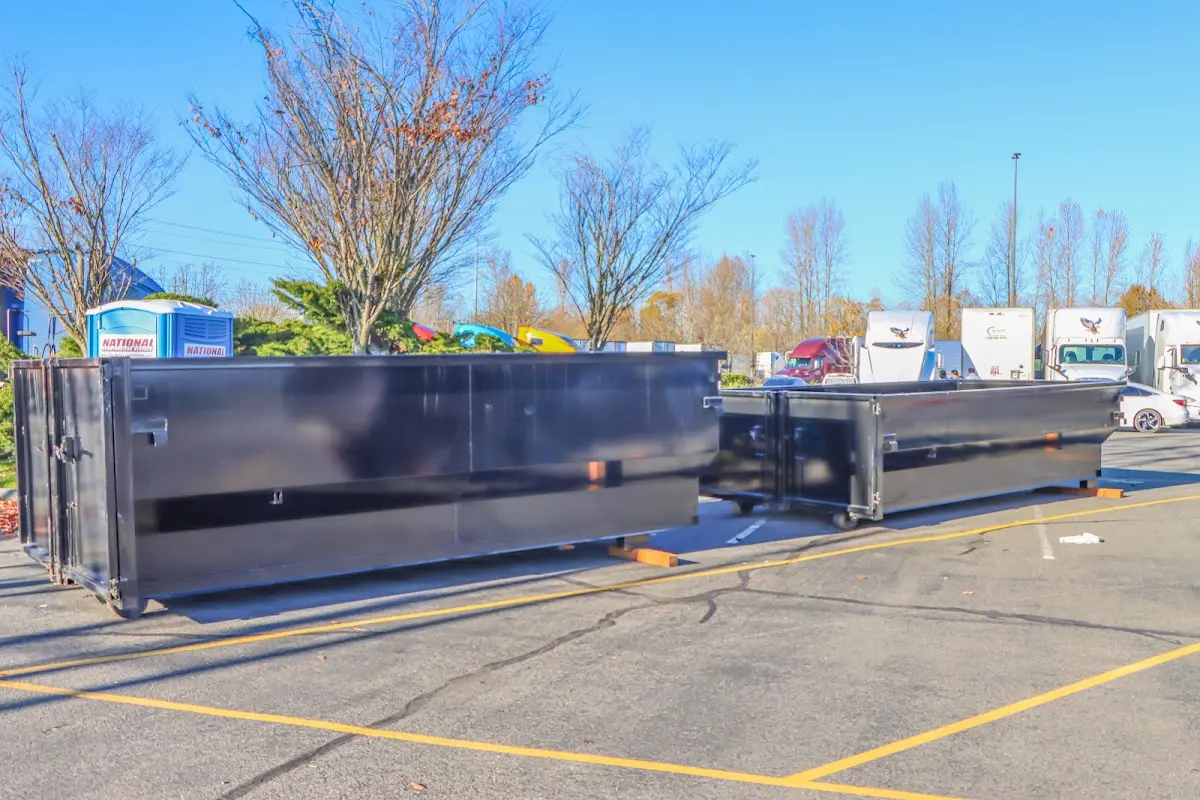 Professional dumpster rental service with roll-off container on residential driveway in Kings Park West